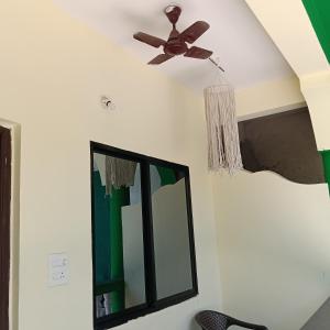 a ceiling fan and mirror in a room at One love guest house morjim in Arambol