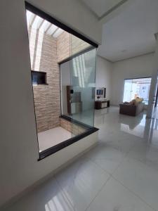 a large glass window in a living room with a couch at Casa de 3 Quartos a 500mts da Praia do Araçagy in São Luís