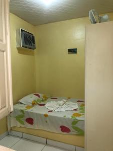 a small bedroom with a bed with flowers on it at Pousada Tia Tita in Cayru