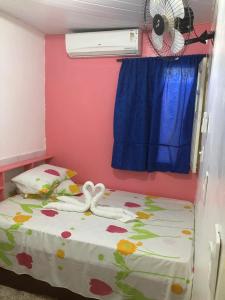 a bedroom with a bed and a fan at Pousada Tia Tita in Cayru +6 photos