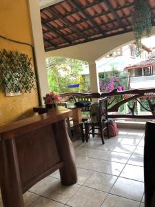 a dining room with a table and chairs and a window at Pousada Tia Tita in Cayru