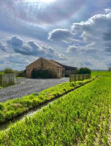a barn in a field next to a gravel road at Little welham in Bedale