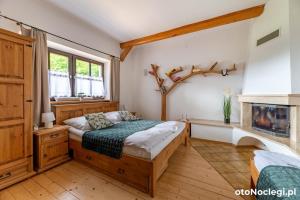 a bedroom with a bed and a fireplace at Dolina Rastoki in Koniaków
