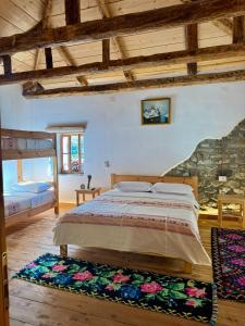FishtëにあるGuesthouse Vitoria - Mrizi i Zanaveの石壁のベッドルーム1室(大型ベッド1台付)