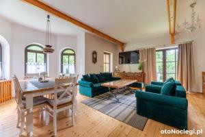 a dining room and living room with a table and chairs at Dolina Rastoki in Koniaków