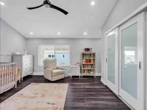 a white nursery with a chair and a crib at Oceanfront Mansion With Boat & Jet Ski in Key Largo