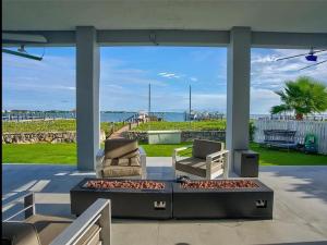 a patio with two chairs and a coffee table with a view of the ocean at Oceanfront Mansion With Boat & Jet Ski in Key Largo