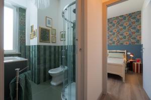 a bathroom with a shower and a toilet and a sink at Essenza Suite Appartments in Rimini +25 photos