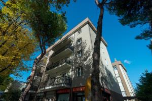 an apartment building in the city with trees at Essenza Suite Appartments in Rimini