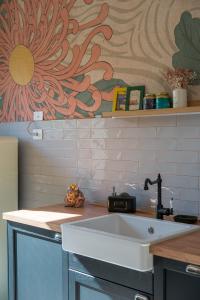 a kitchen with a sink and a flower on the wall at Essenza Suite Appartments in Rimini