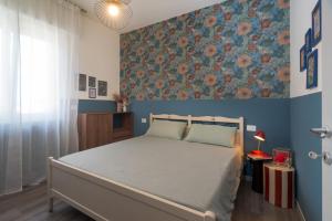 a bedroom with a bed and a floral wall at Essenza Suite Appartments in Rimini