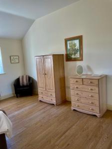 a bedroom with a wooden dresser and a cabinet at Little welham in Bedale