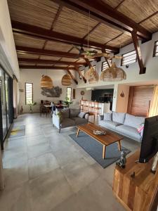 a living room with a couch and a table at Villa lagoon view Baie du cap bel ombre in Baie du Cap