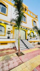 eine Palme vor einem Gebäude mit Treppe in der Unterkunft Jai Pushkara Luxe Stay -Luxury Heritage Hotel in Pushkar