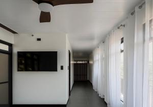 a hallway with white walls and a flat screen tv at Balai de Biday 4 Pax Suite with Free Breakfast in Mameltac