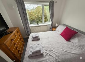 FlookburghにあるWillow Chalet near Cartmel & Lake Windermereのベッドルーム1室(ドレッサー付きのベッド1台、窓付)