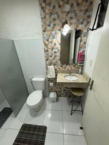 Un baño con inodoro, lavabo y espejo. en Recoleta Rent Suite, en Asunción