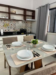 una mesa de comedor con platos blancos. en Recoleta Rent Suite, en Asunción