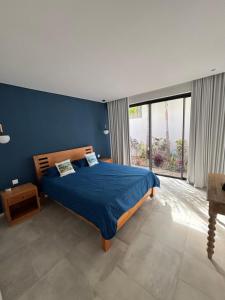 a blue bedroom with a bed and a large window at Villa lagoon view Baie du cap bel ombre in Baie du Cap +45 photos