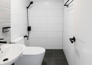 a white bathroom with a toilet and a sink at Balai de Biday 4 Pax Suite with Breakfast Option in Mameltac +10 photos