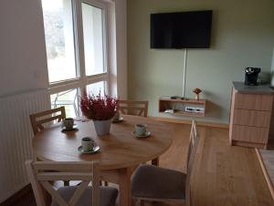 a dining room with a table with chairs and a television at Górski Wypoczynek in Szczawnica +23 photos