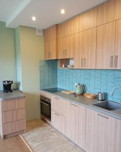 a kitchen with wooden cabinets and a sink at Górski Wypoczynek in Szczawnica