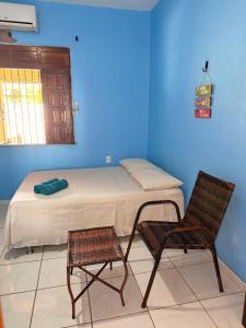 a bed and a chair in a room with blue walls at Lavi Hostel in Alter do Chao +103 photos