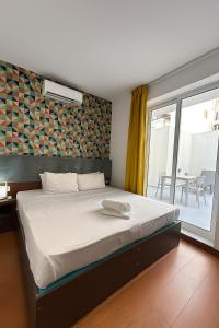 a bedroom with a bed and a large window at Dar One - Self catering & self check in apartments by Tritoni Hotels in Il-Gżira