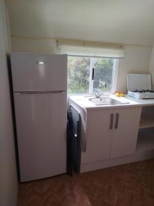 eine kleine Küche mit Kühlschrank und Spüle in der Unterkunft Camping el Palomar in Alhama de Almería