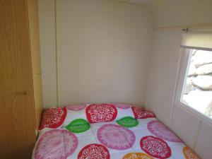 ein Bett in einem kleinen Zimmer mit Regenschirmen darauf in der Unterkunft Camping el Palomar in Alhama de Almería