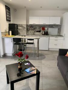ein Wohnzimmer mit Tisch und Küche in der Unterkunft Beau Studio climatisé, parking privé Sanary centre in Sanary-sur-Mer