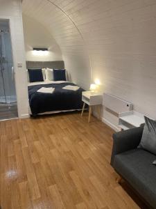 a bedroom with a bed and a couch in a room at AfonCoed - A cozy, quiet stay by the river in Llanrhaeadr-ym-Mochnant