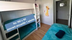 Ein Schlafzimmer mit zwei Etagenbetten und einer Katze an der Wand in der Unterkunft Apt Disneyland 2 chambres, parking, bus sur place in Montévrain