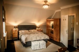a bedroom with a large bed and a chandelier at Landhaus Frank in Kirchberg am Wechsel