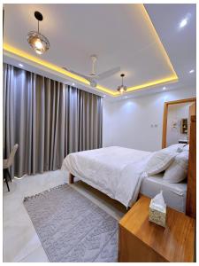 a bedroom with a large white bed and a window at Sandy shores apartments in Kikambala