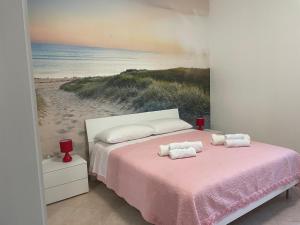 a bedroom with a pink bed and a painting of a beach at Baita Monte Caruso in Filiano