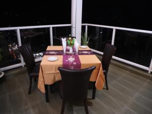 シレットにあるLa Vista Suites Sylhetのダイニングルーム(椅子付)が備わり、市街の景色を望めます。