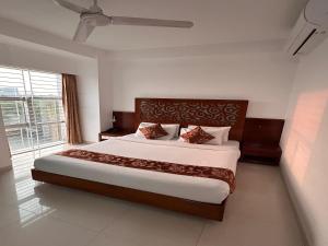 シレットにあるLa Vista Suites Sylhetの大きなベッドと大きな窓のある寝室 +23枚の写真