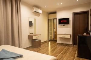 Cette chambre dispose d'un lit et d'une télévision murale. dans l'établissement Pyraking Pyramids View Hotel, à Giza