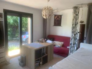 a living room with a red couch and a window at Chambre au calme in Lambesc