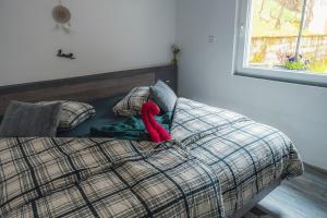 a red teddy bear laying on top of a bed at Apartma in wellness Mesečina in Libeliče