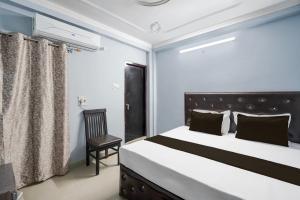 a bedroom with a bed and a chair at Hotel O STAR GALAXY in Bhauli