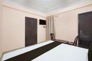 a bedroom with a bed and a tv and a window at Hotel O STAR GALAXY in Bhauli