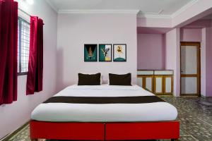 a large bed in a room with red and white walls at HOTEL O REEYH INN in Khāpri