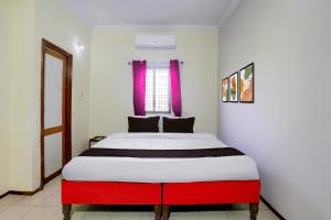 a red and white bed in a white room at HOTEL O REEYH INN in Khāpri