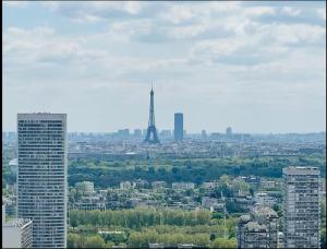 a view of a city with the eiffel tower at Apartment Paris La Défense Eiffel Tower Skyline in Puteaux