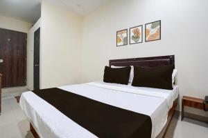 a bedroom with a large black and white bed at Hotel O Elegance Inn in Virār +28 photos