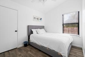 a white bedroom with a bed and a window at Spacious Family Home in Round Rock w Private Yard in Round Rock
