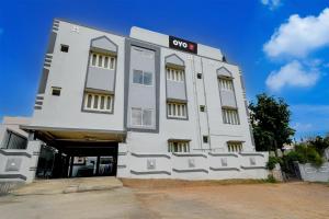 een wit gebouw met een bord erop bij SPOT ON Harshitha Guest House in Pedda Ambarpet