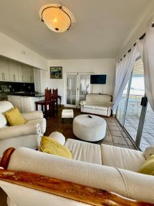 a living room with white couches and a table at Beachfront Apartment in Tergniet